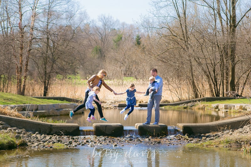 family walking across path over water