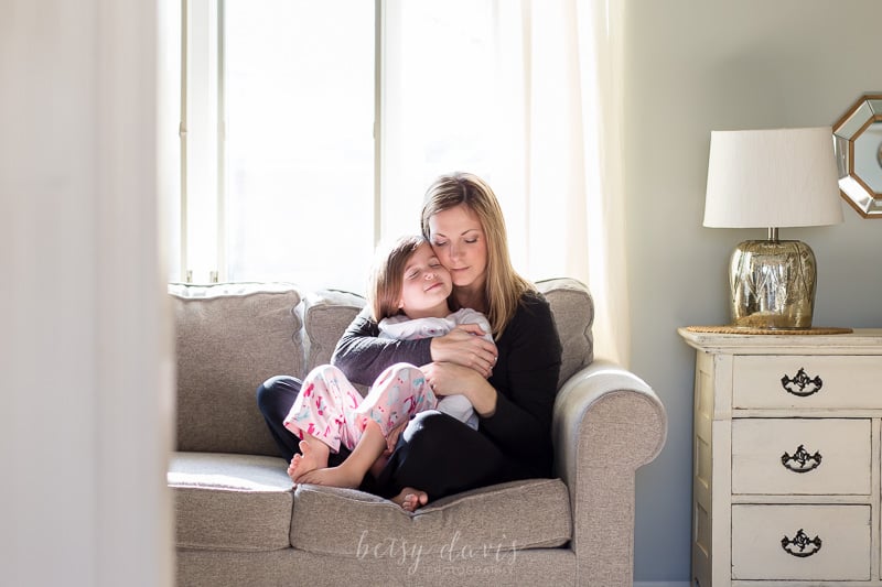 woman hugging child on couch