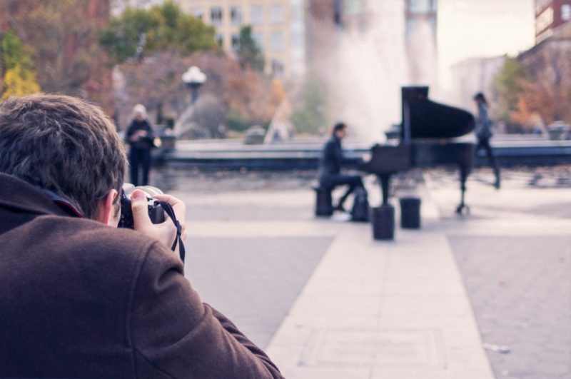 man taking a picture of a pianist