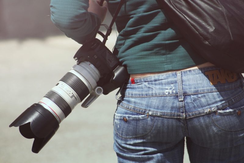 Fotógrafo segurando uma câmera com teleobjetiva