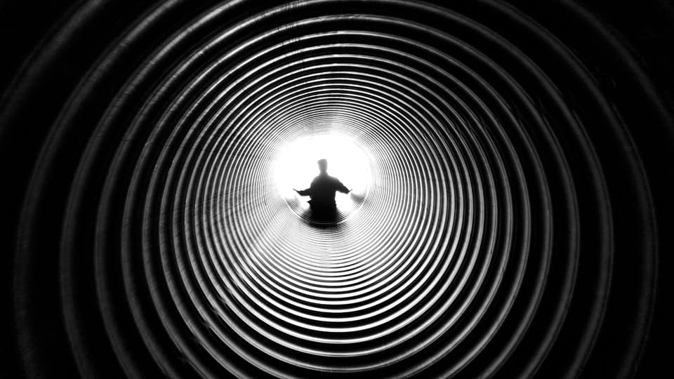 man at the end of spiral tunnel