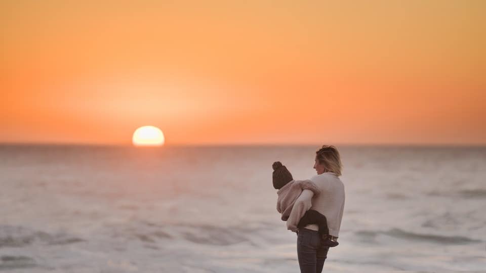 mother and child watching beach sunset