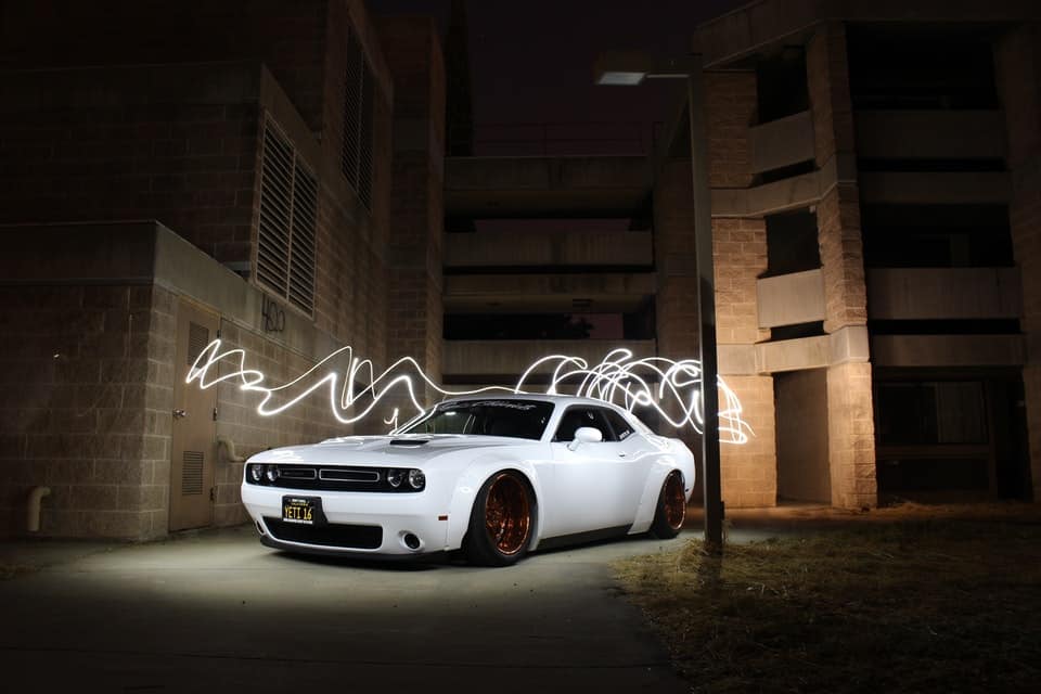 white race car with artistic lights behind 