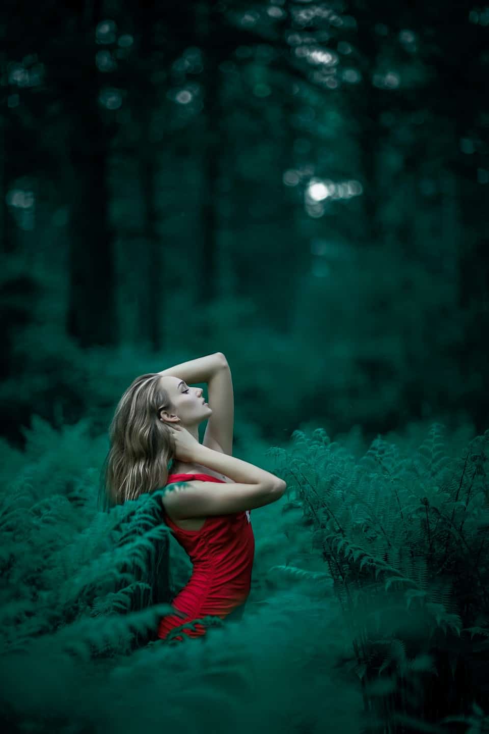 woman in red dress posing in forest