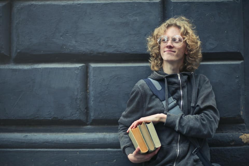 teenage boy holding books
