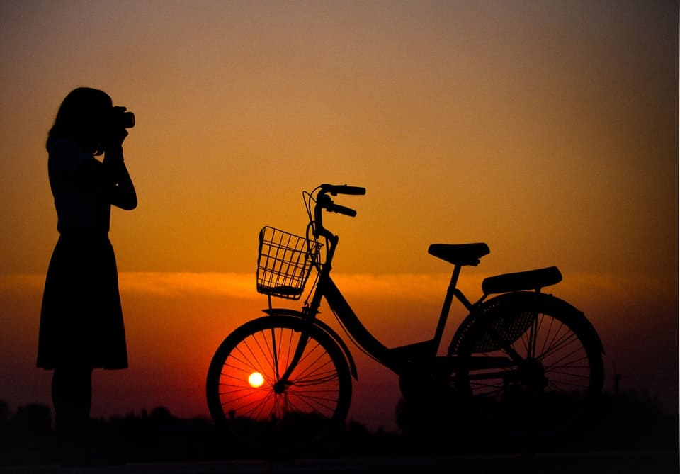 silhouette of woman and bicycle