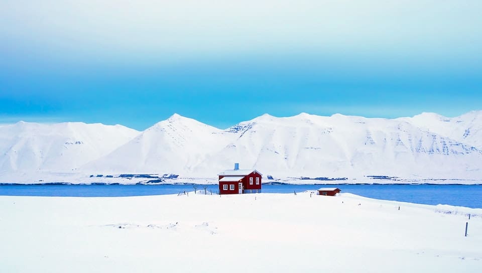 small red house in the middle of snow