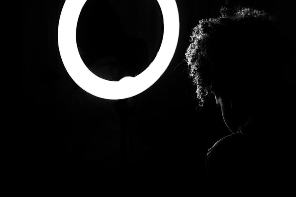 woman sitting in front of ring light