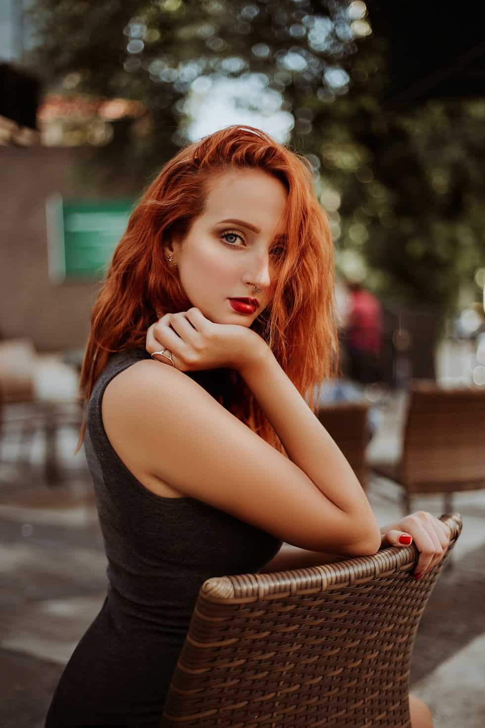 woman with red hair posing on chair